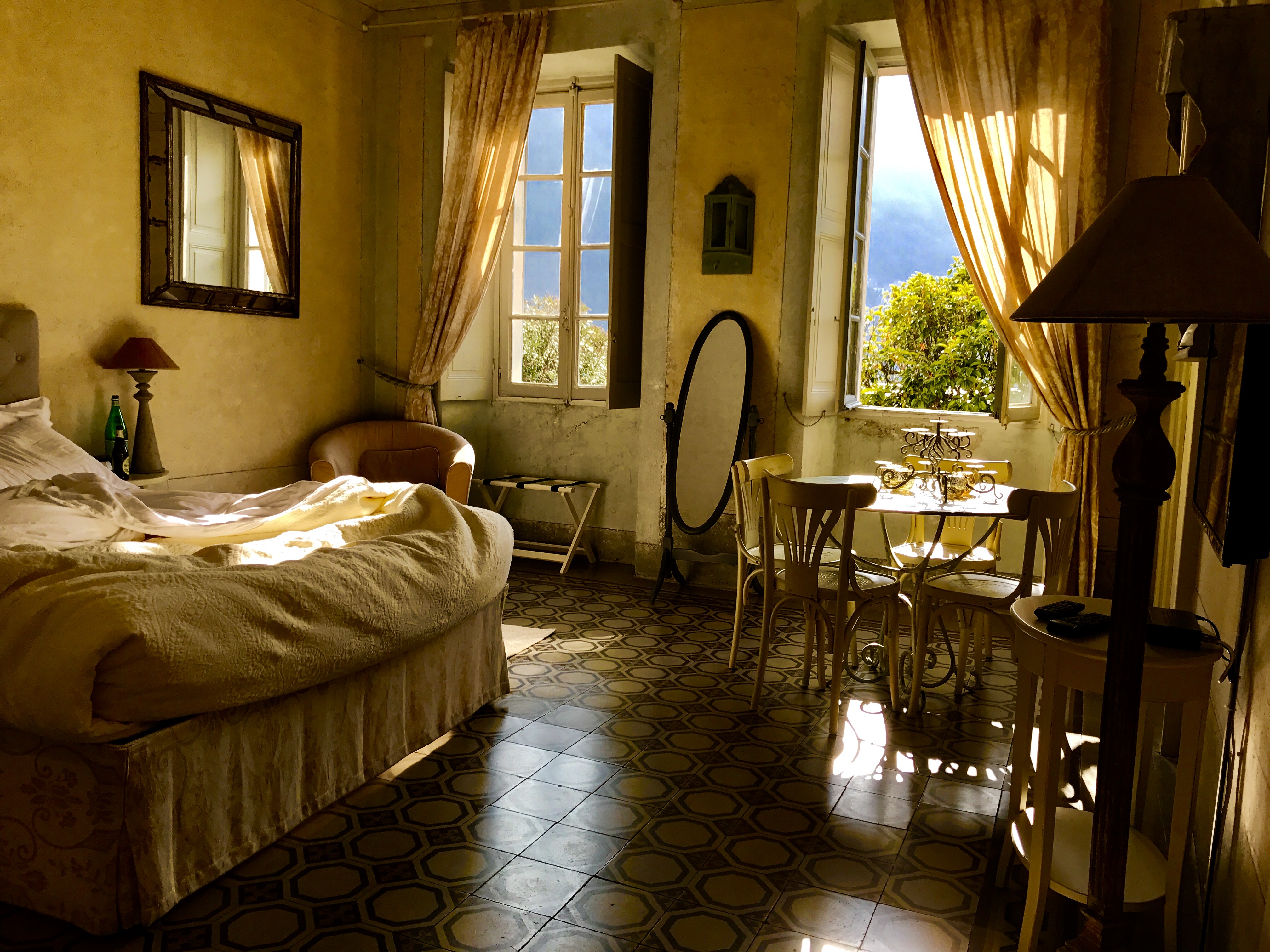 Warm sunlit interior room with open windows and golden curtains.